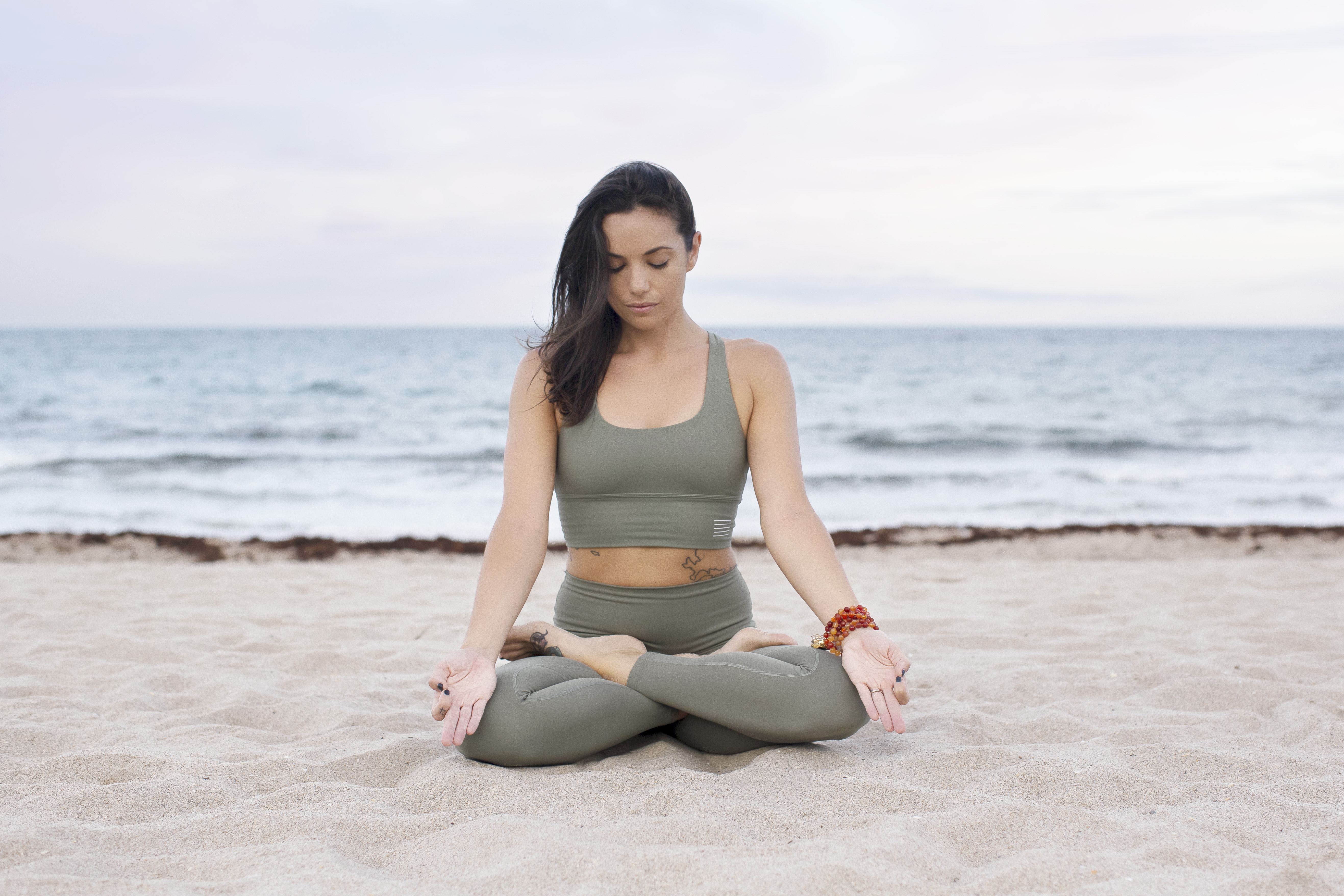 Woman meditating on the beach